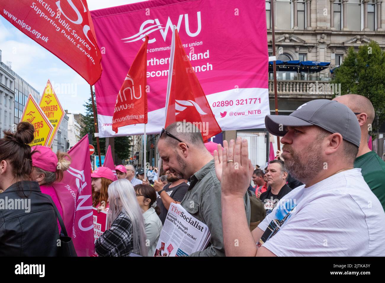 Belfast, Regno Unito. 31 agosto 2022. L'uomo plaude al discorso mentre gli attivisti si riuniscono fuori dal municipio di Belfast per chiedere una retribuzione migliore in mezzo all'aumento dei costi della vita durante il Communication Workers Union NI Strike Rally. Bandiere CWU e striscioni sindacali che sventolano. Foto Stock