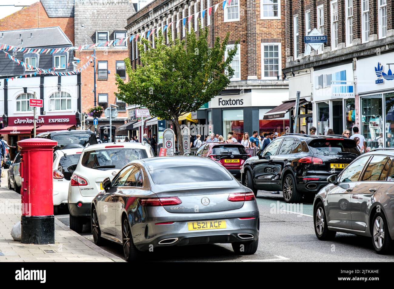 Kingston-upon-Thames, Londra, Regno Unito, agosto 29 2022, vetture parcheggiate lungo la Main Street Shopping Area con Red Post Box con acquirenti o consumatori Foto Stock