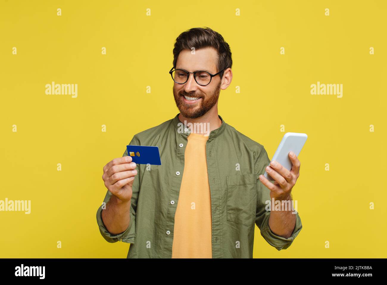 Concetto di portafoglio online. Felice uomo di mezza età in possesso di smartphone e carta di credito, shopping, acquisti via internet Foto Stock