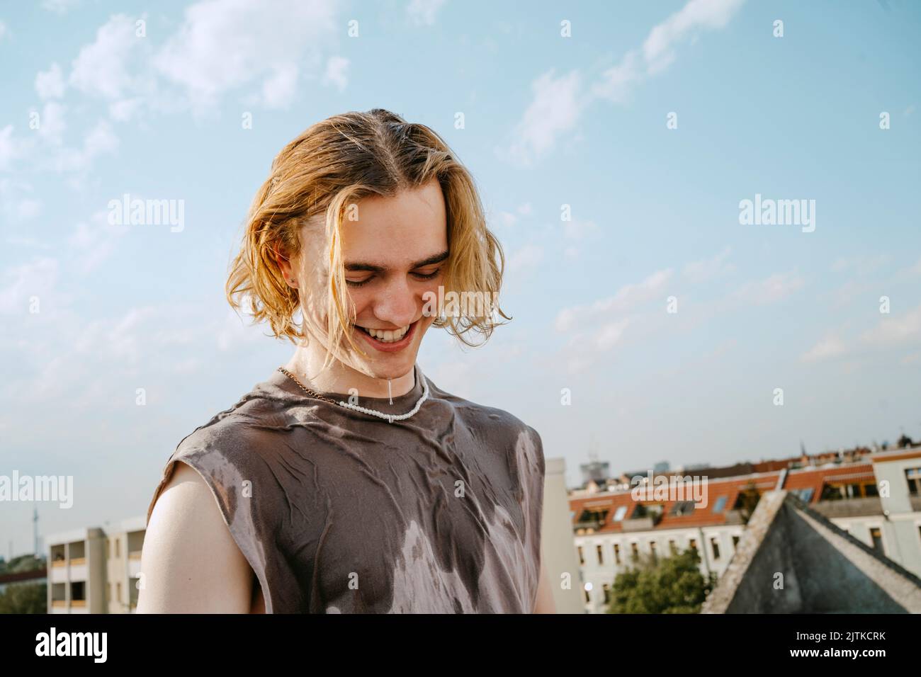 Felice giovane uomo con capelli biondi contro il cielo Foto Stock
