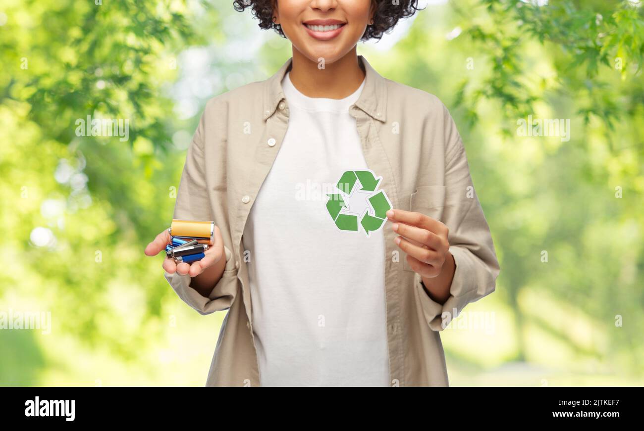 donna con cartello verde di riciclaggio e batterie Foto Stock