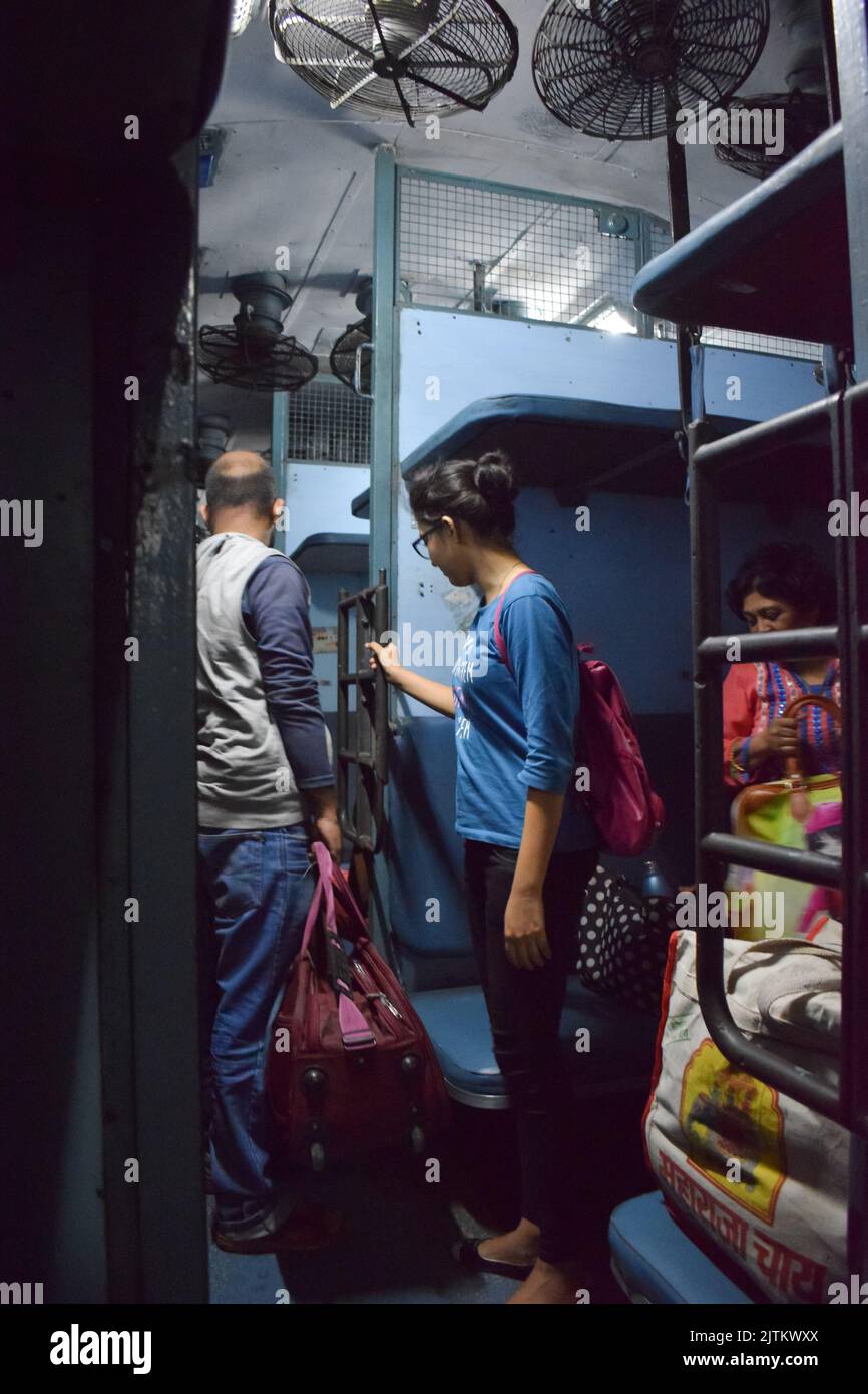 Viaggiatori ferroviari indiani con bagagli. Foto Stock