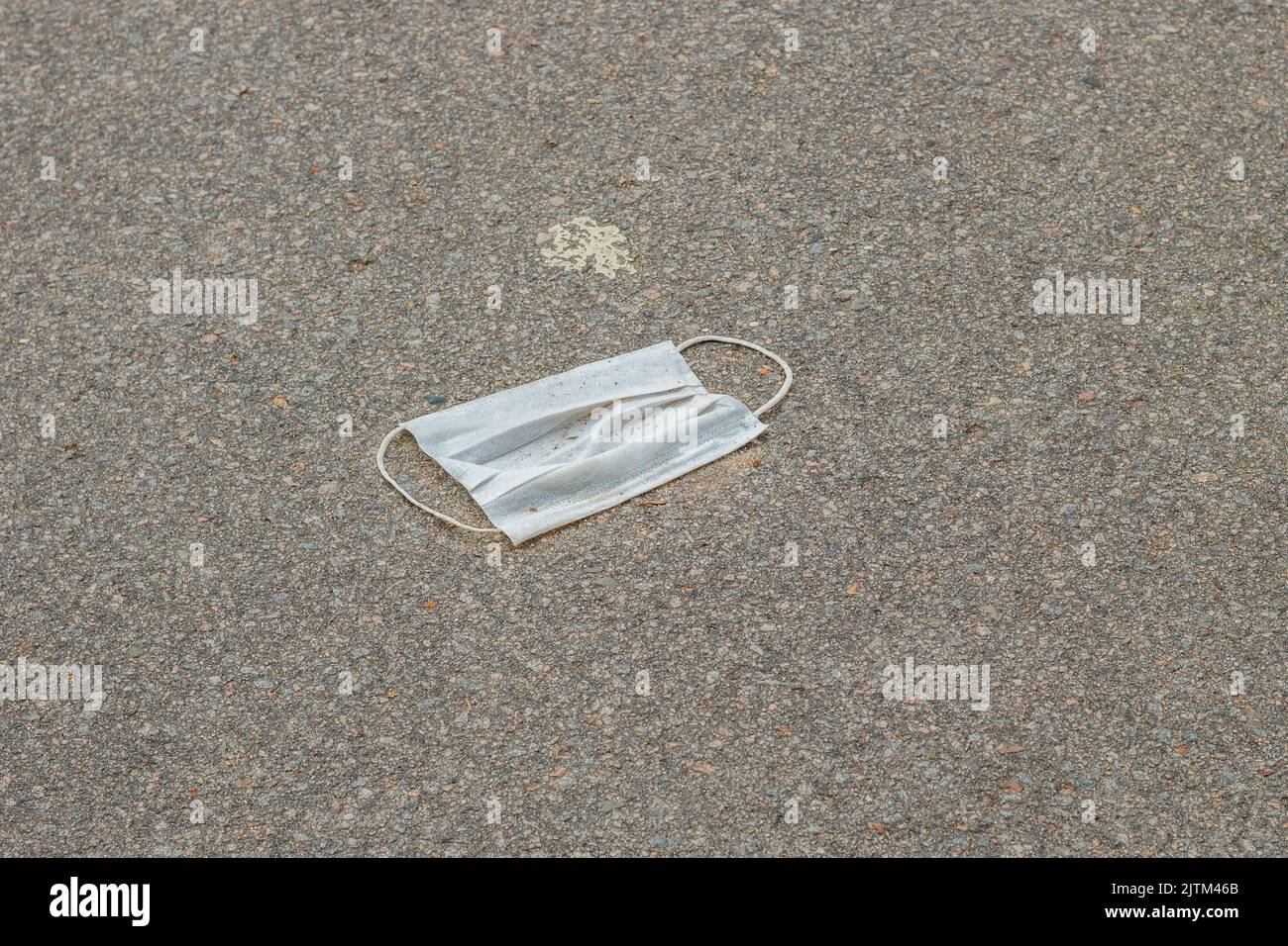 Maschera protettiva monouso blu, utilizzata per la protezione contro il cornavirus, gettata sull'asfalto a Rio de Janeiro. Foto Stock