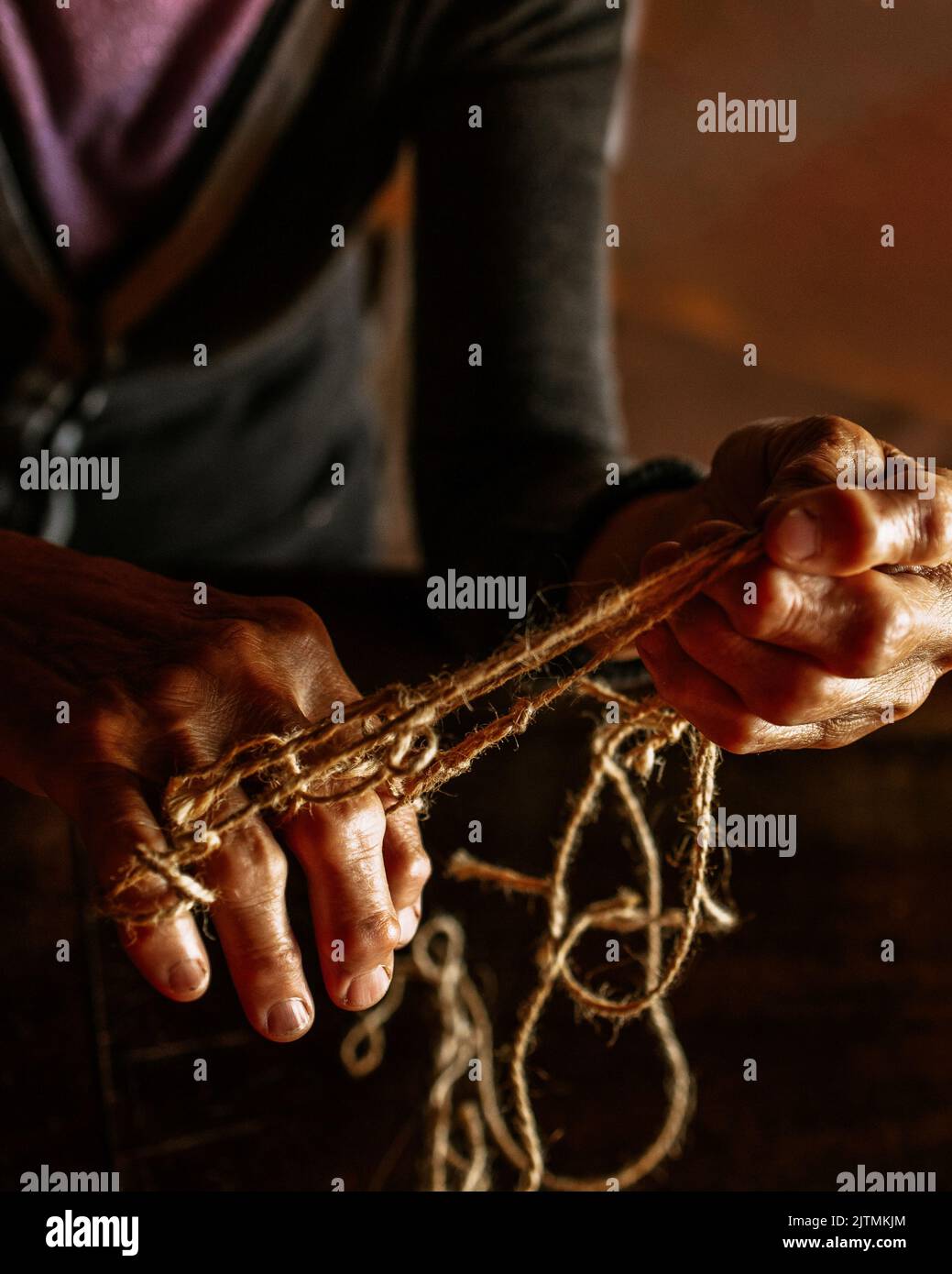 Mani di vecchia donna con malattia di poliartrite. Corde di tela sulle dita della signora anziana, marionette. Foto di alta qualità Foto Stock