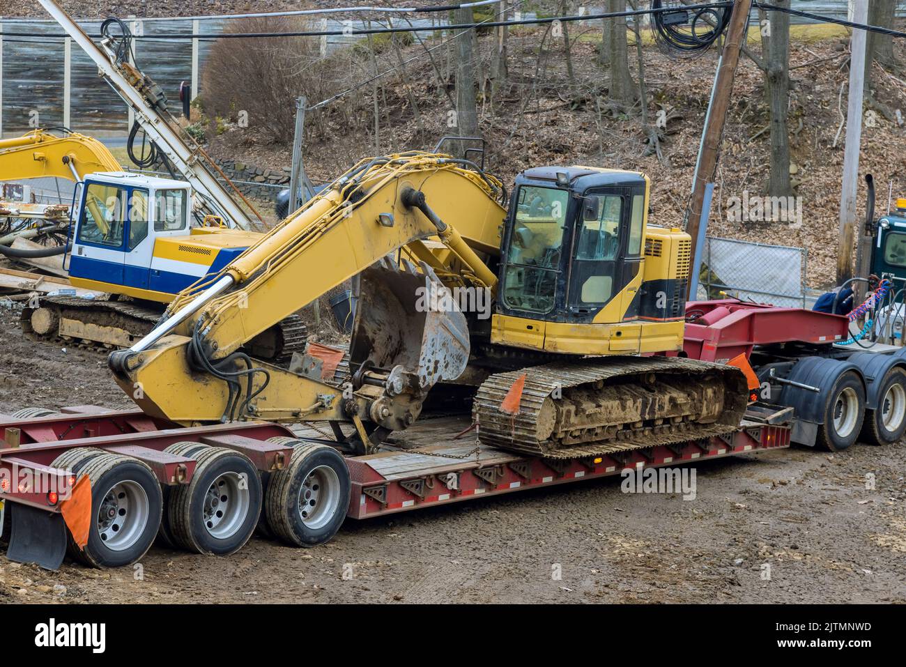 L'uso di una piattaforma per rimorchio per trasportare attrezzature da cantiere pesanti in autostrada è un'attività pericolosa Foto Stock