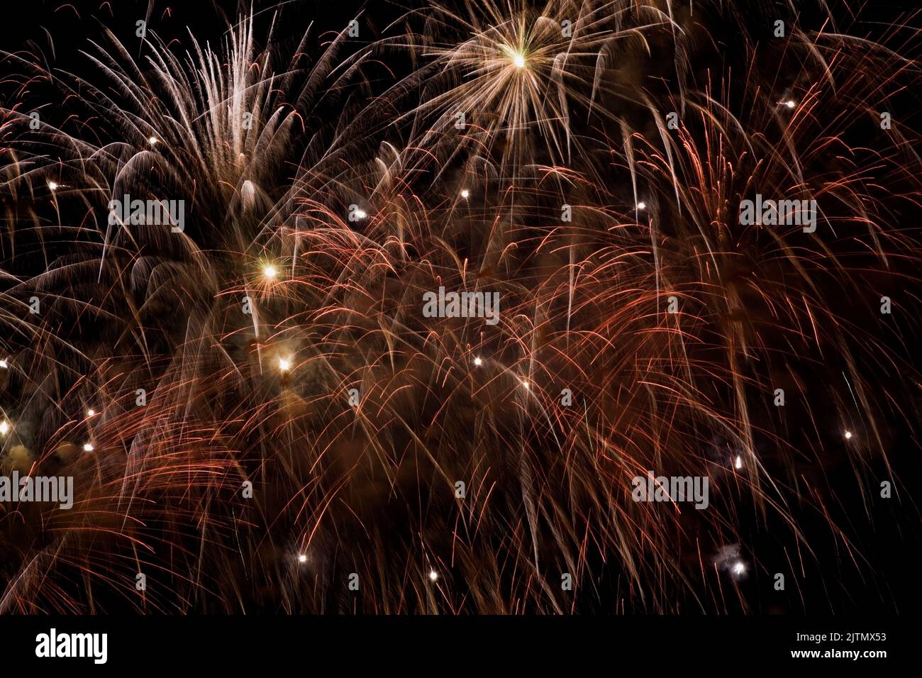 Fuochi d'artificio arancioni, rossi e dorati nel cielo notturno. Foto Stock
