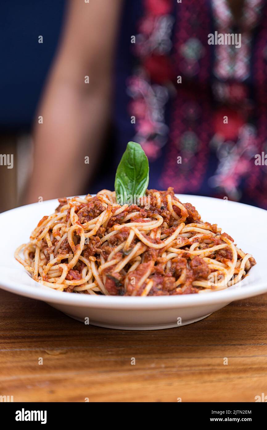Fettuccine con bolognese e foglia di basilico in un ristorante italiano Foto Stock