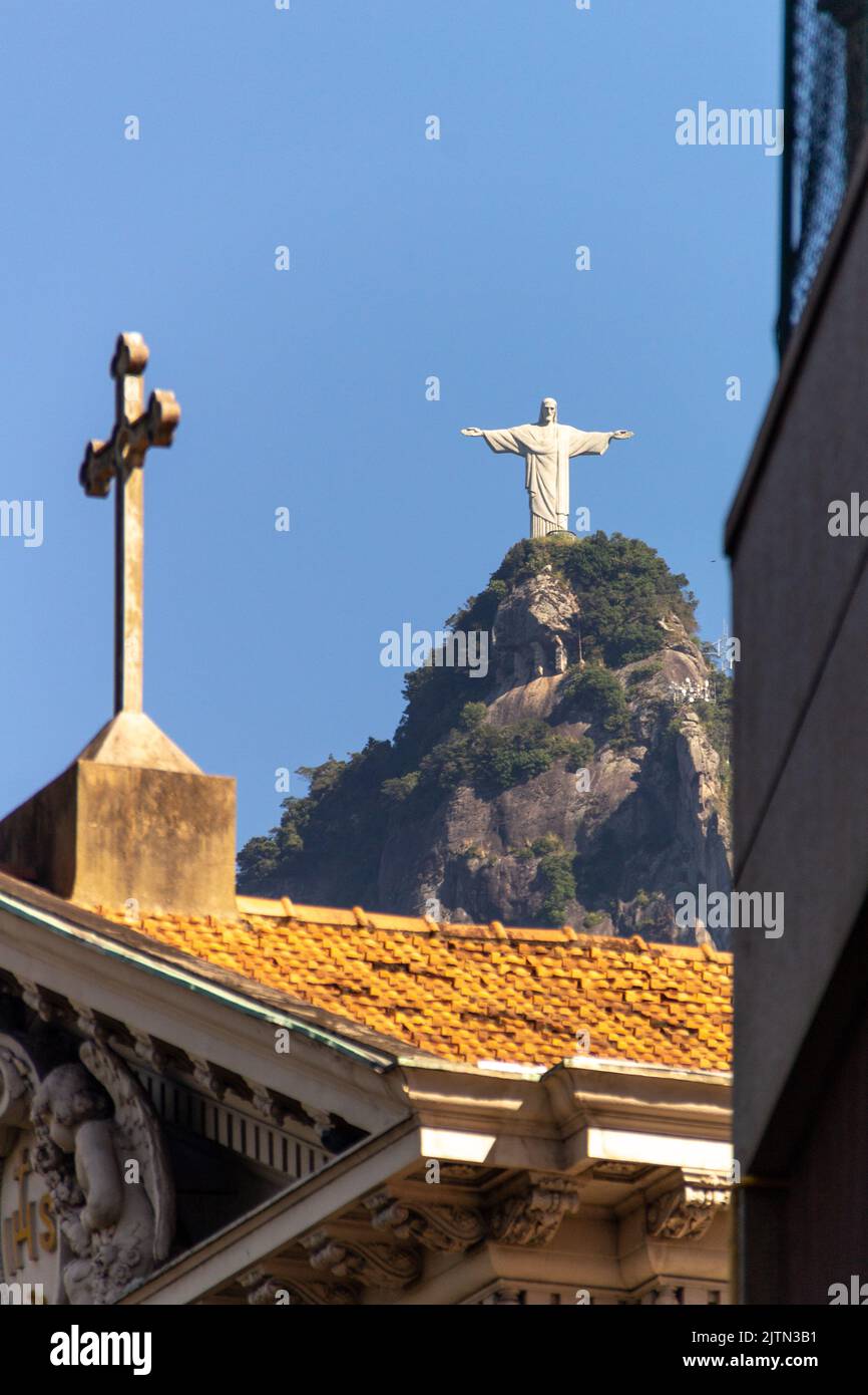 Cristo Redentore e croce di una chiesa, a Rio de Janeiro, Brasile - 12 maggio 2020: Cristo Redentore e croce di una chiesa in primo piano Foto Stock