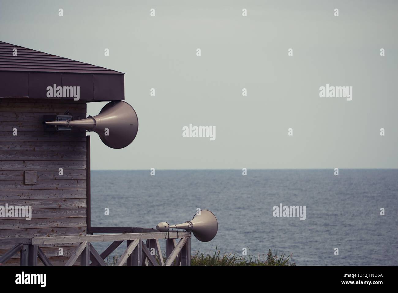 Due altoparlanti del sistema di allarme rapido sull'edificio in riva al mare, Hokkaido, Giappone Foto Stock