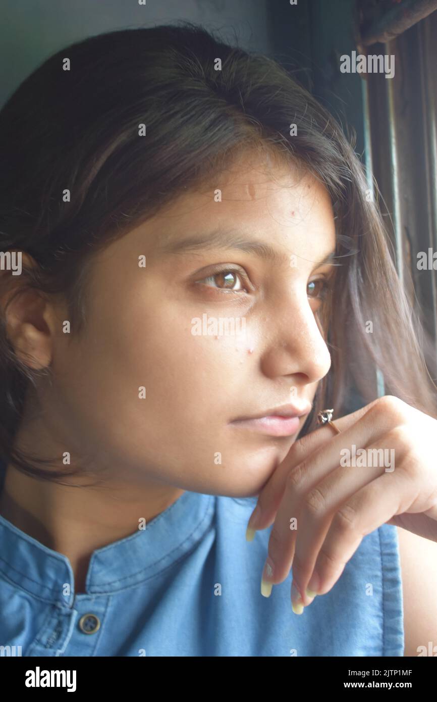 Una giovane donna che viaggia in treno in India Foto Stock