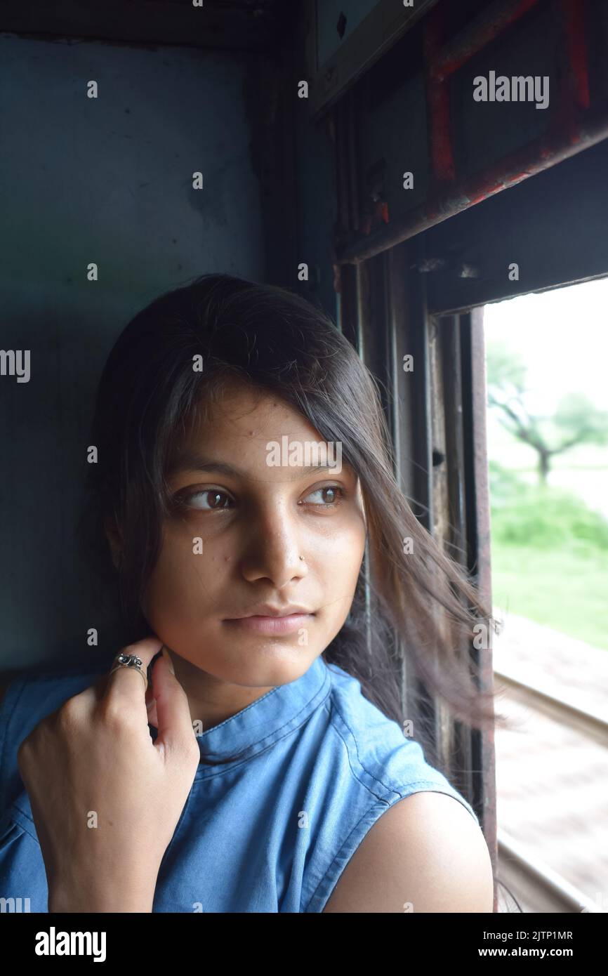 Una giovane donna che viaggia in treno in India Foto Stock