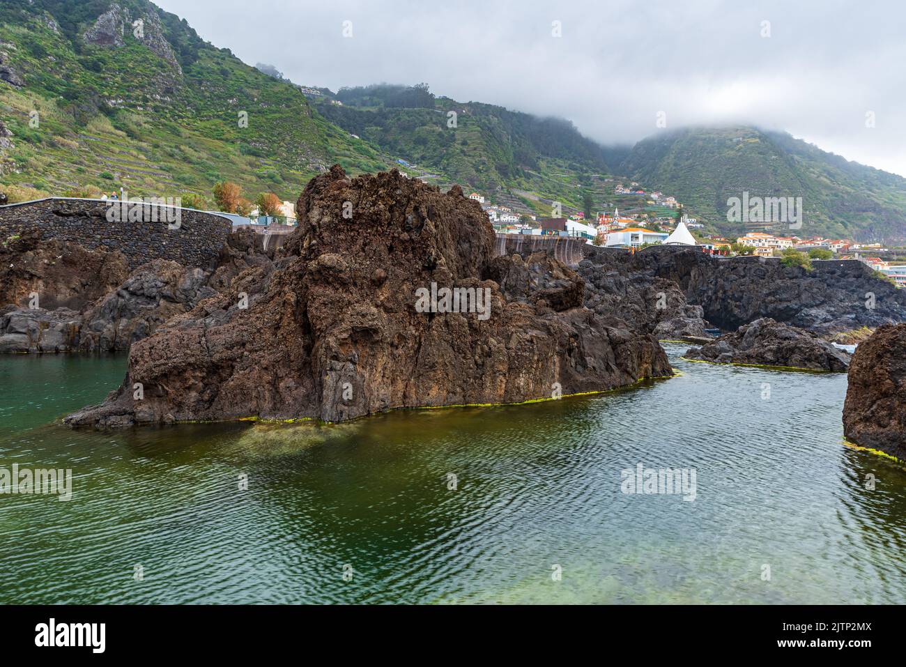Piscina naturale con rocce vulcaniche a Porto Moniz a Madeira durante la nuvolosa giornata primaverile Foto Stock