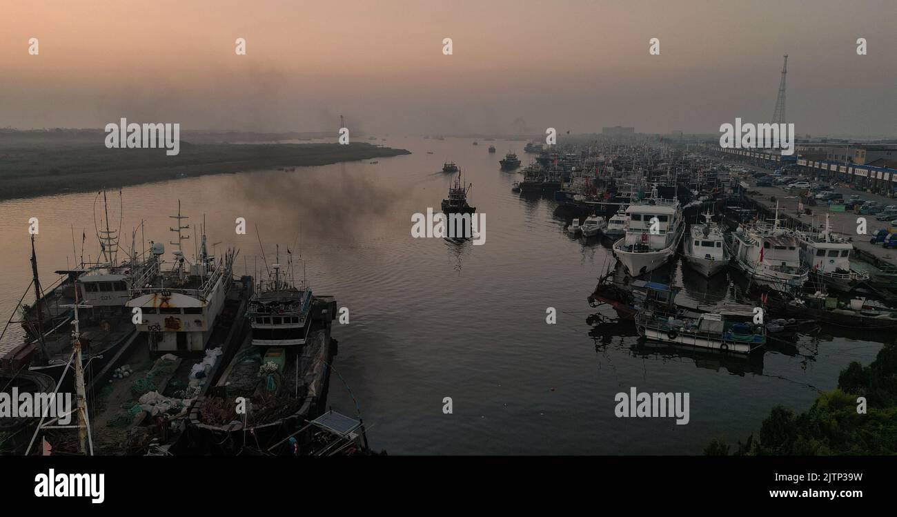 DONGYING, CINA - 1 SETTEMBRE 2022 - le barche da pesca pronte per uscire in mare approfittano dell'alta marea mattutina per regolare i loro ormeggi al canto Foto Stock