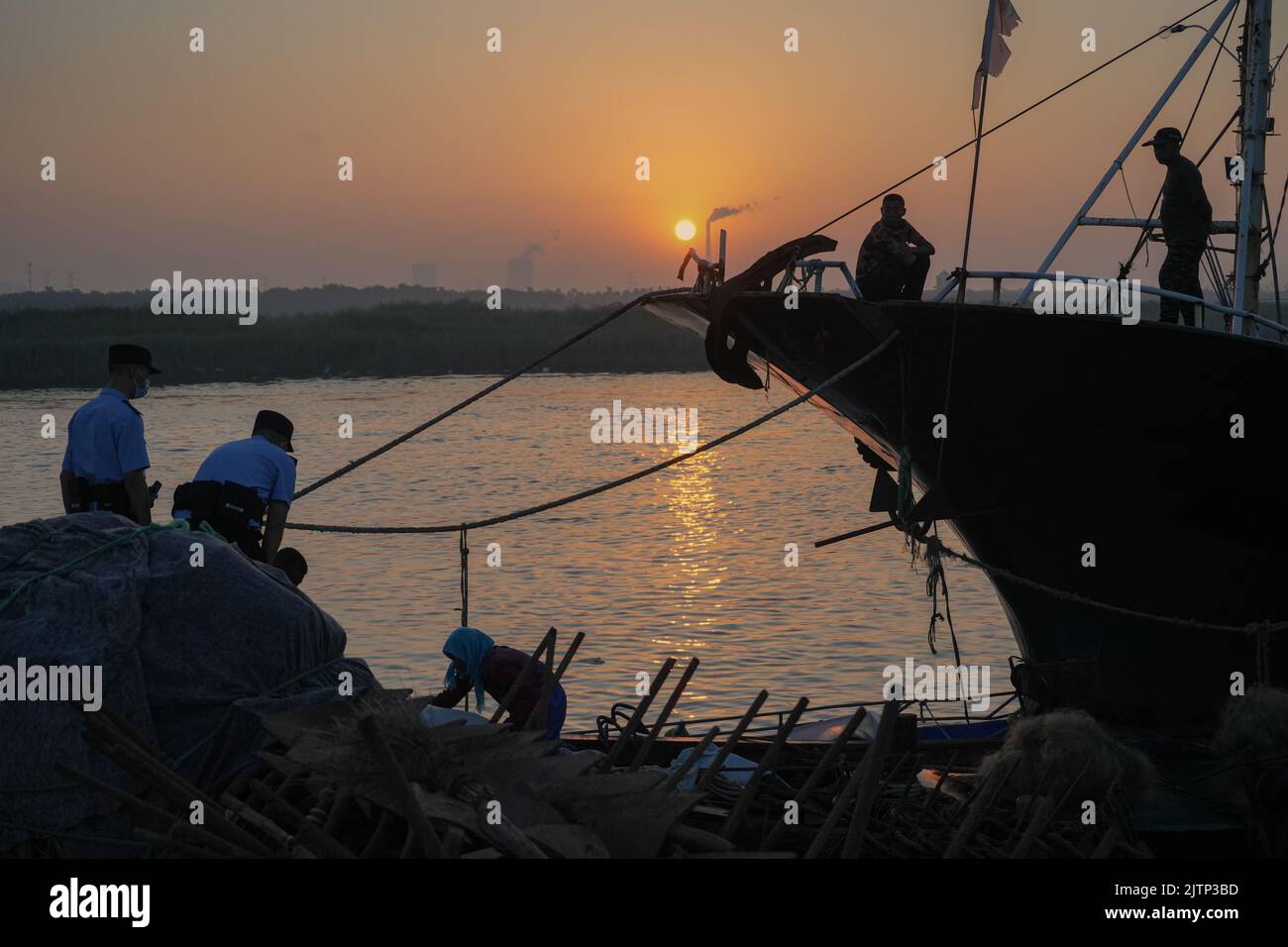 DONGYING, CINA - 1 SETTEMBRE 2022 - i poliziotti imparano circa la situazione di produzione dei pescatori che si preparano per la navigazione nella città di Dongying, Shandong pro Foto Stock