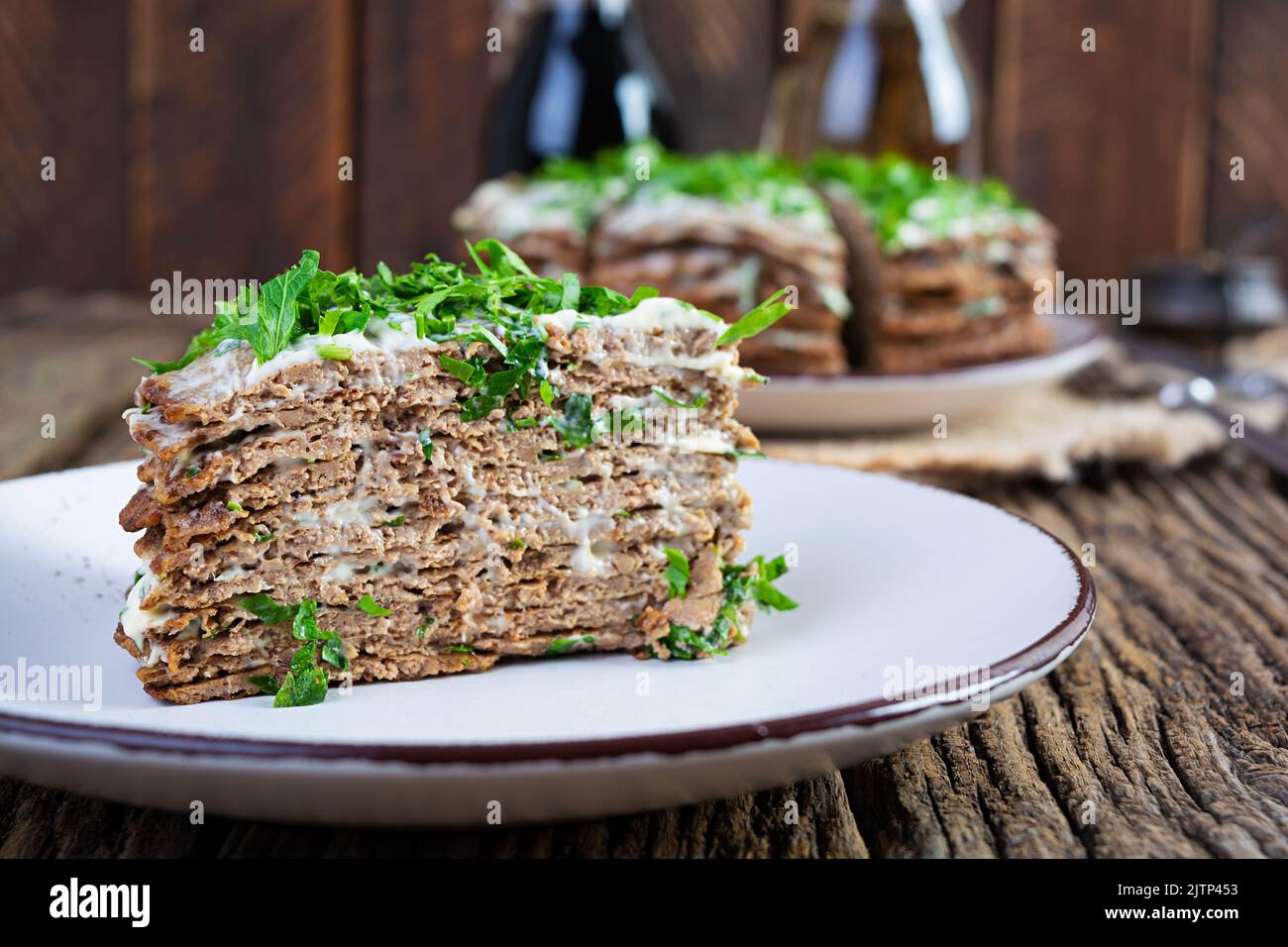 Torta di fegato su sfondo di legno. Torta al fegato a fette con maionese Foto Stock