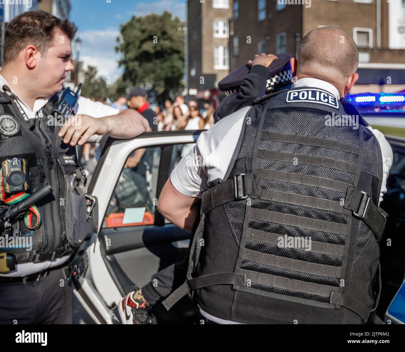 Gli agenti di polizia si occupa di un bambino che ha perso i suoi genitori al Carnevale di Notting Hill. Foto Stock