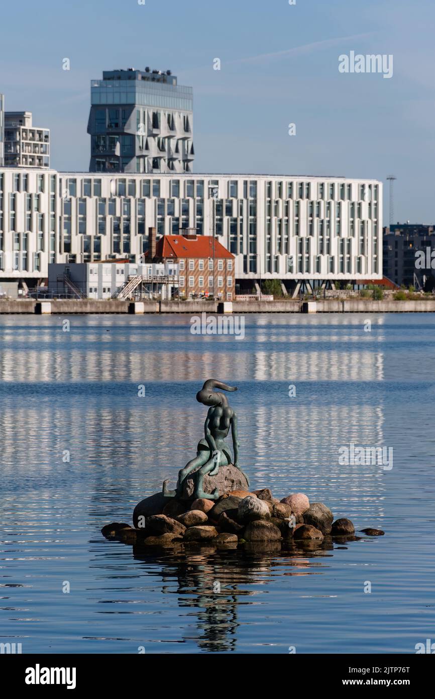 Copenaghen, Danimarca. Agosto 13, 2022. Piccola scultura di sirena geneticamente modificata con edifici della città delle Nazioni Unite sullo sfondo. Foto Stock