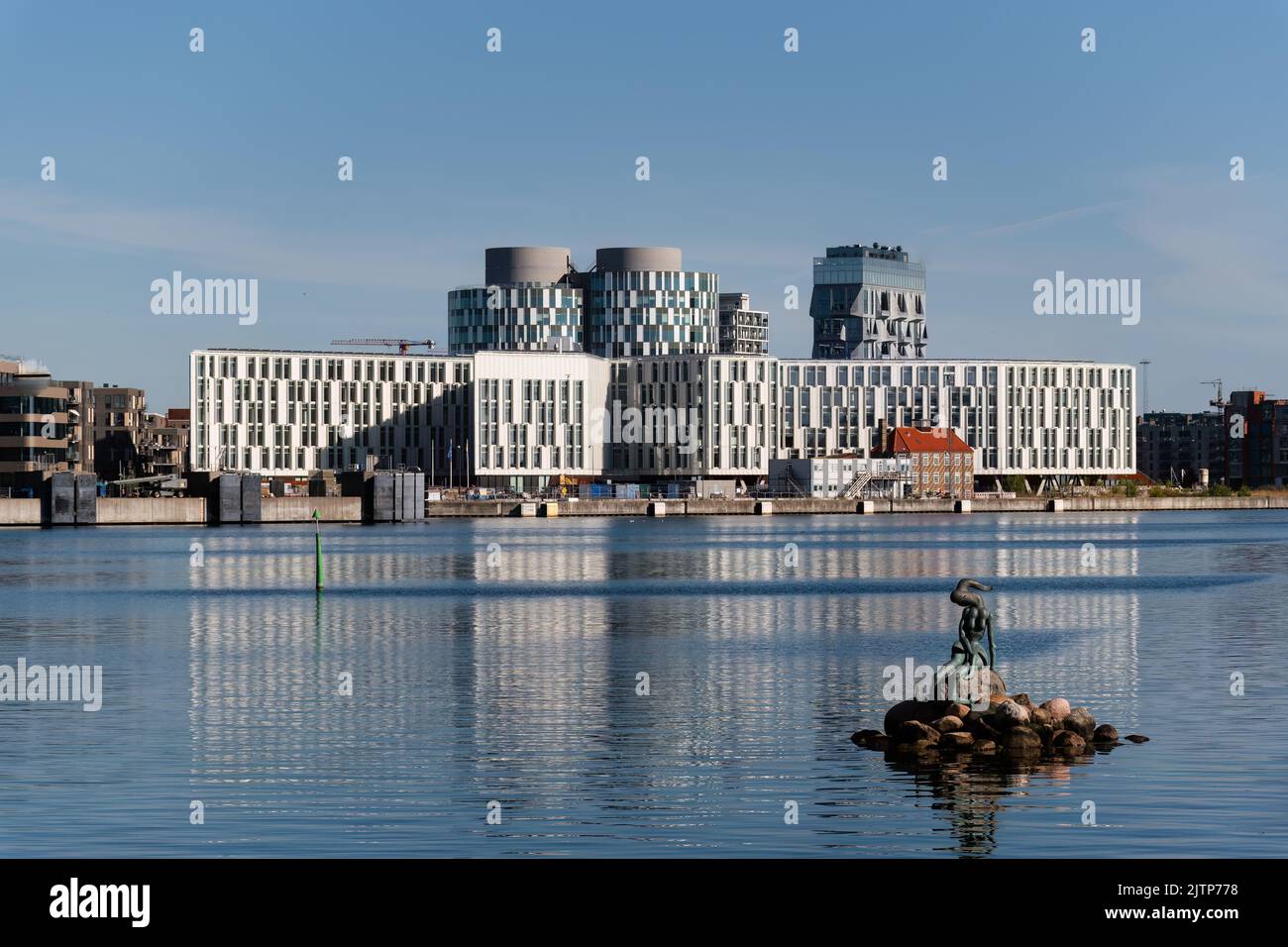 Copenaghen, Danimarca. Agosto 13, 2022. Piccola scultura di sirena geneticamente modificata con edifici della città delle Nazioni Unite sullo sfondo. Foto Stock
