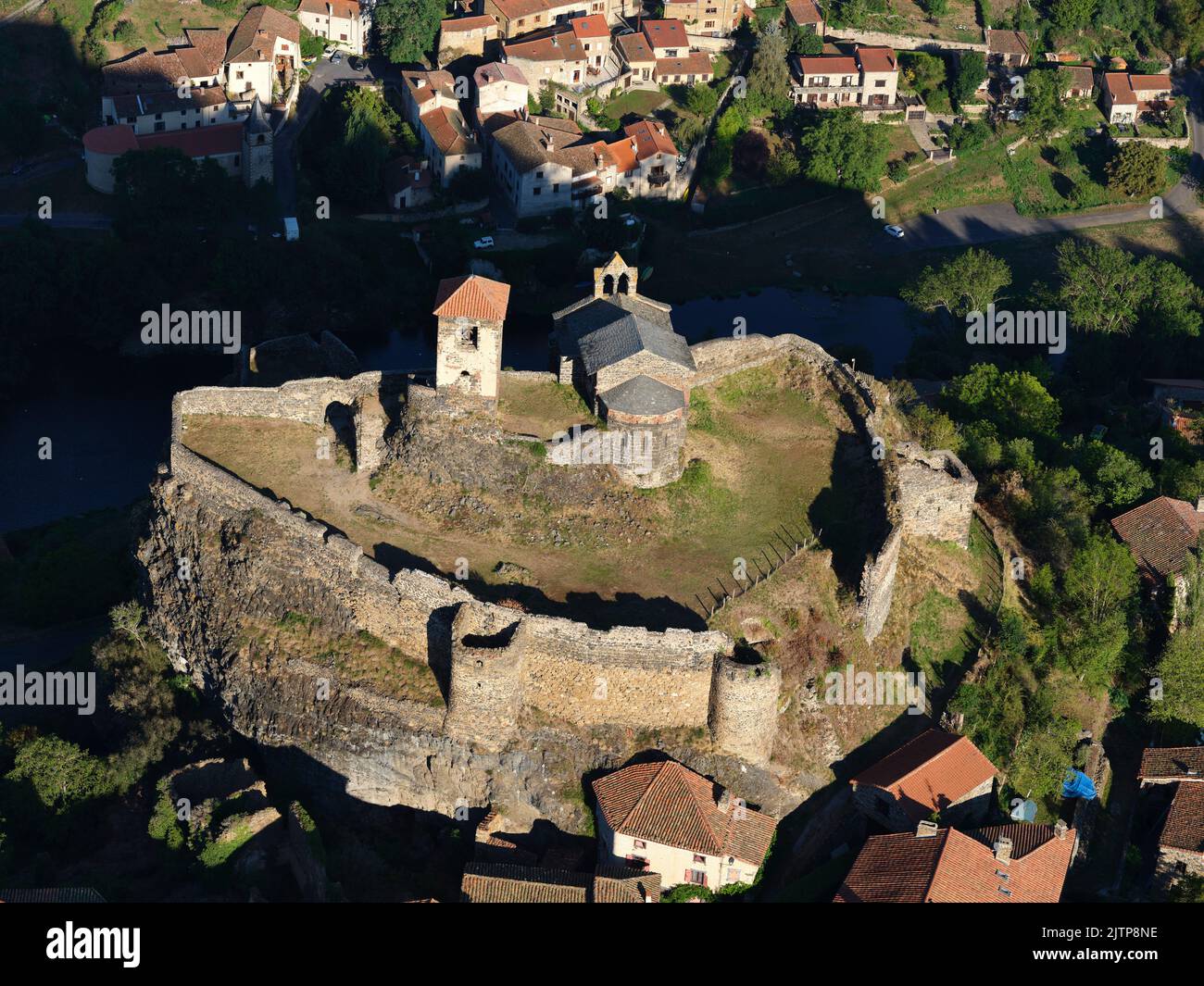 VISTA AEREA. Castello di Saint-Ilpize arroccato su un promontorio roccioso sopra il fiume Allier. Saint-Ilpize, alta Loira, Auvergne-Rhône-Alpes, Francia. Foto Stock