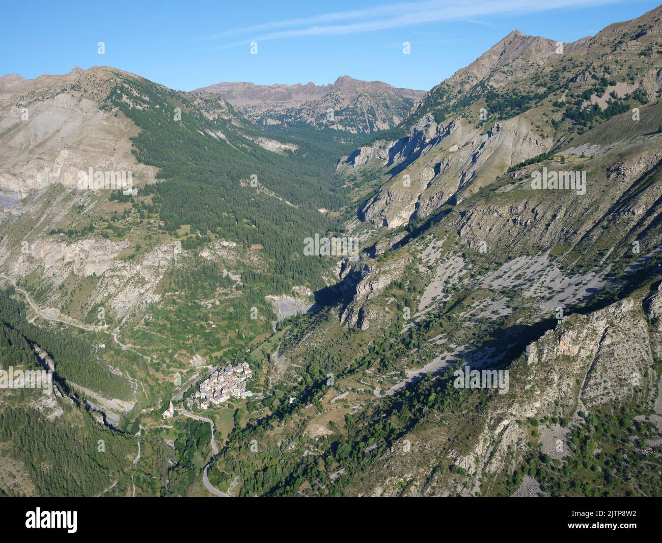 VISTA AEREA. Piccolo villaggio nella Valle Tinée ai piedi del Parco Nazionale del Mercantour. Alpes-Maritimes, Provence-Alpes-Côte d'Azur, Francia. Foto Stock