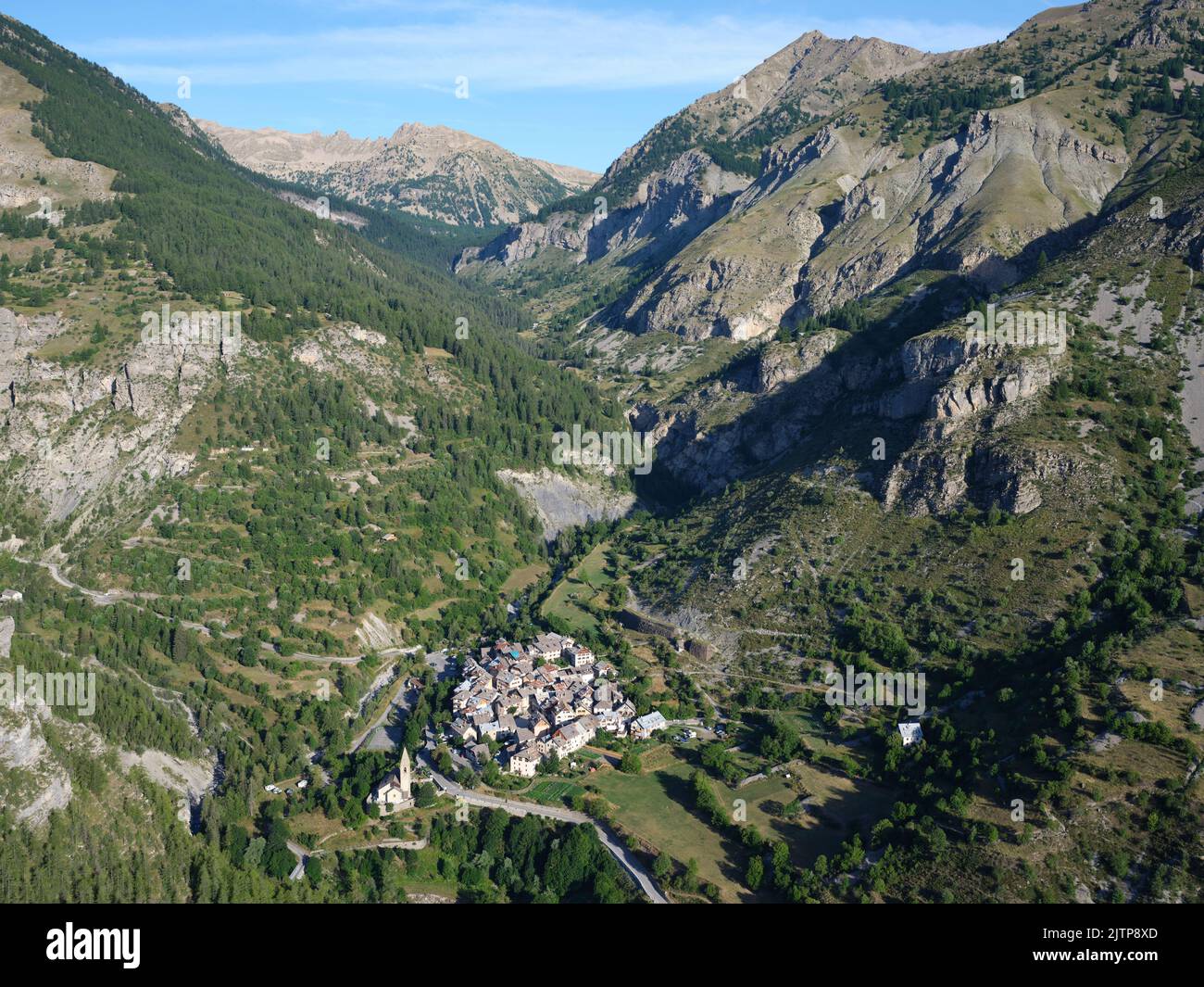 VISTA AEREA. Piccolo villaggio nella Valle Tinée ai piedi del Parco Nazionale del Mercantour. Alpes-Maritimes, Provence-Alpes-Côte d'Azur, Francia. Foto Stock