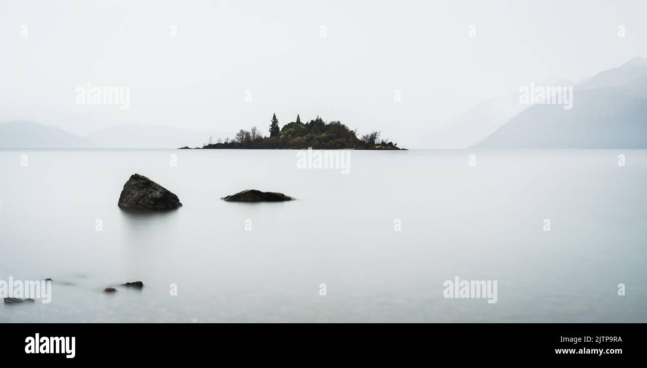 Alta immagine chiave di Ruby Island sul lago Wanaka con montagne sullo sfondo nella nebbia, regione di Otago, Isola del Sud. Foto Stock