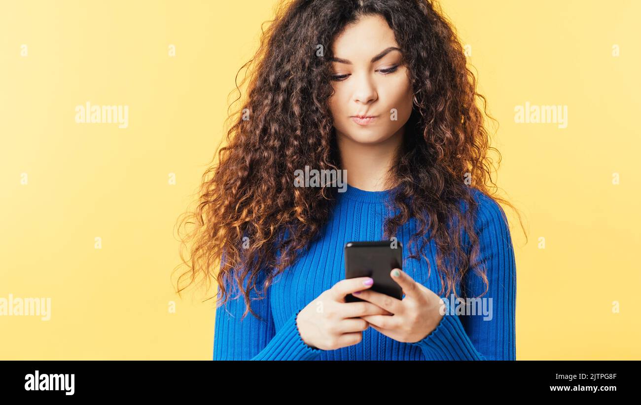 donna smartphone dubbio scetticismo diffidenza Foto Stock