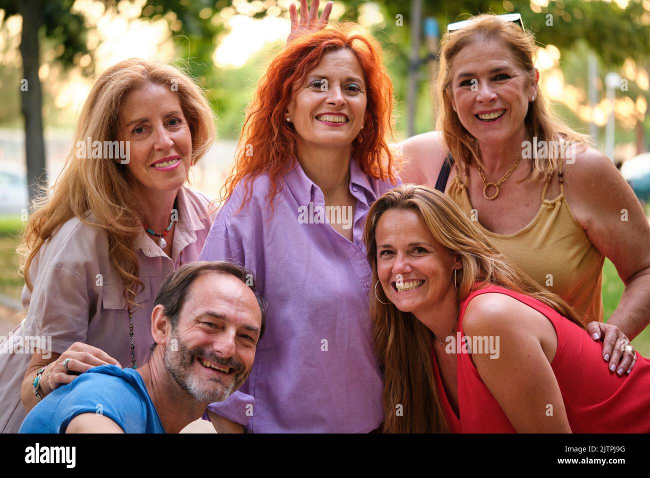 Cinque adulti maturi che prendono un selfie e si divertono in un parco. Foto Stock