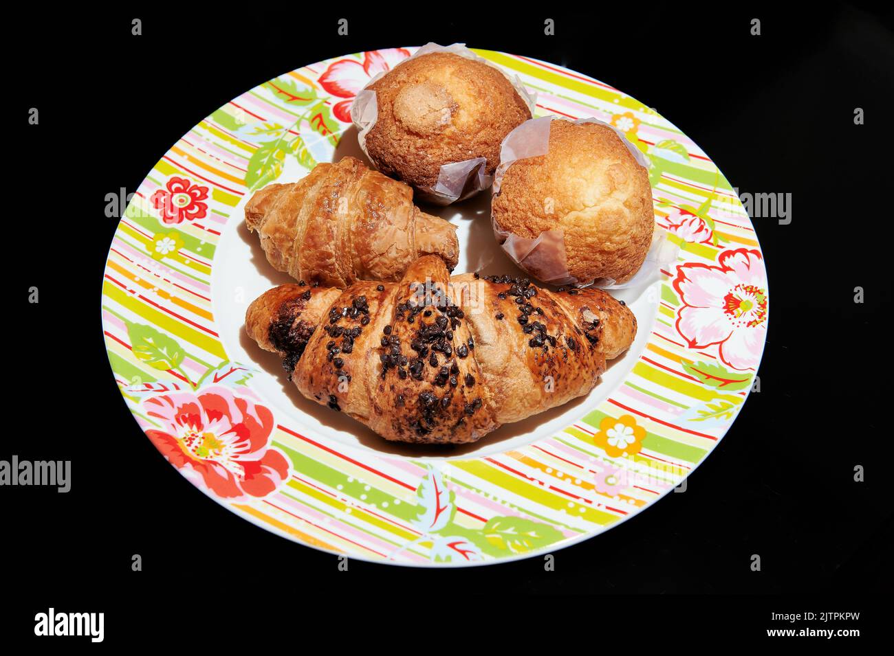 Piatto con croissant al cioccolato e muffin per colazione Foto Stock