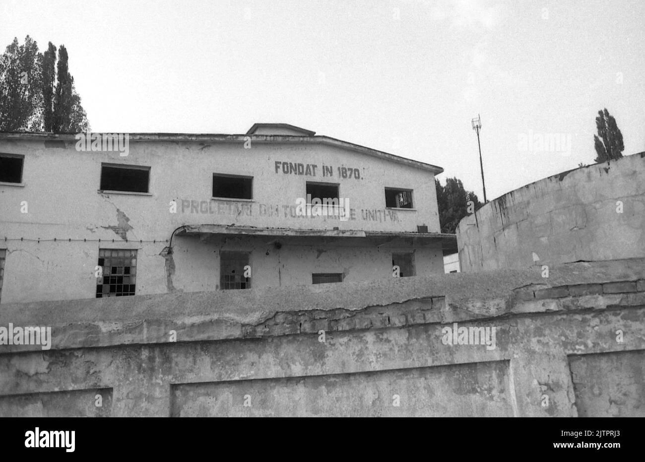 Stabilimento abbandonato in Romania, circa 1992 cca. Due iscrizioni sono ancora visibili sulla facciata: 'Fondata nel 1870' e lo slogan comunista 'operai del mondo, Uniti'. Foto Stock