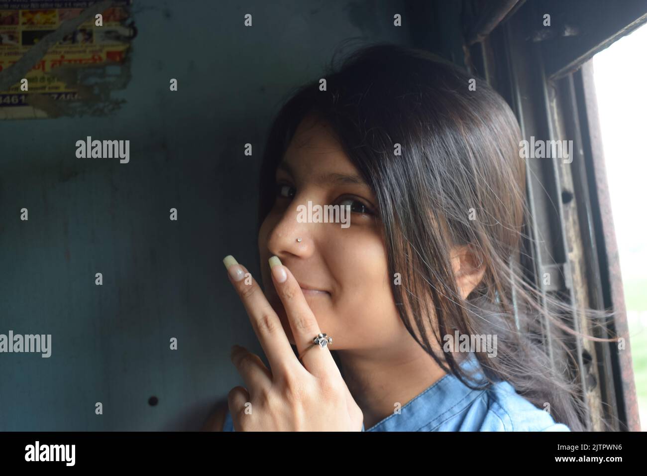 Una giovane donna indiana in posa per la foto in treno. Foto Stock