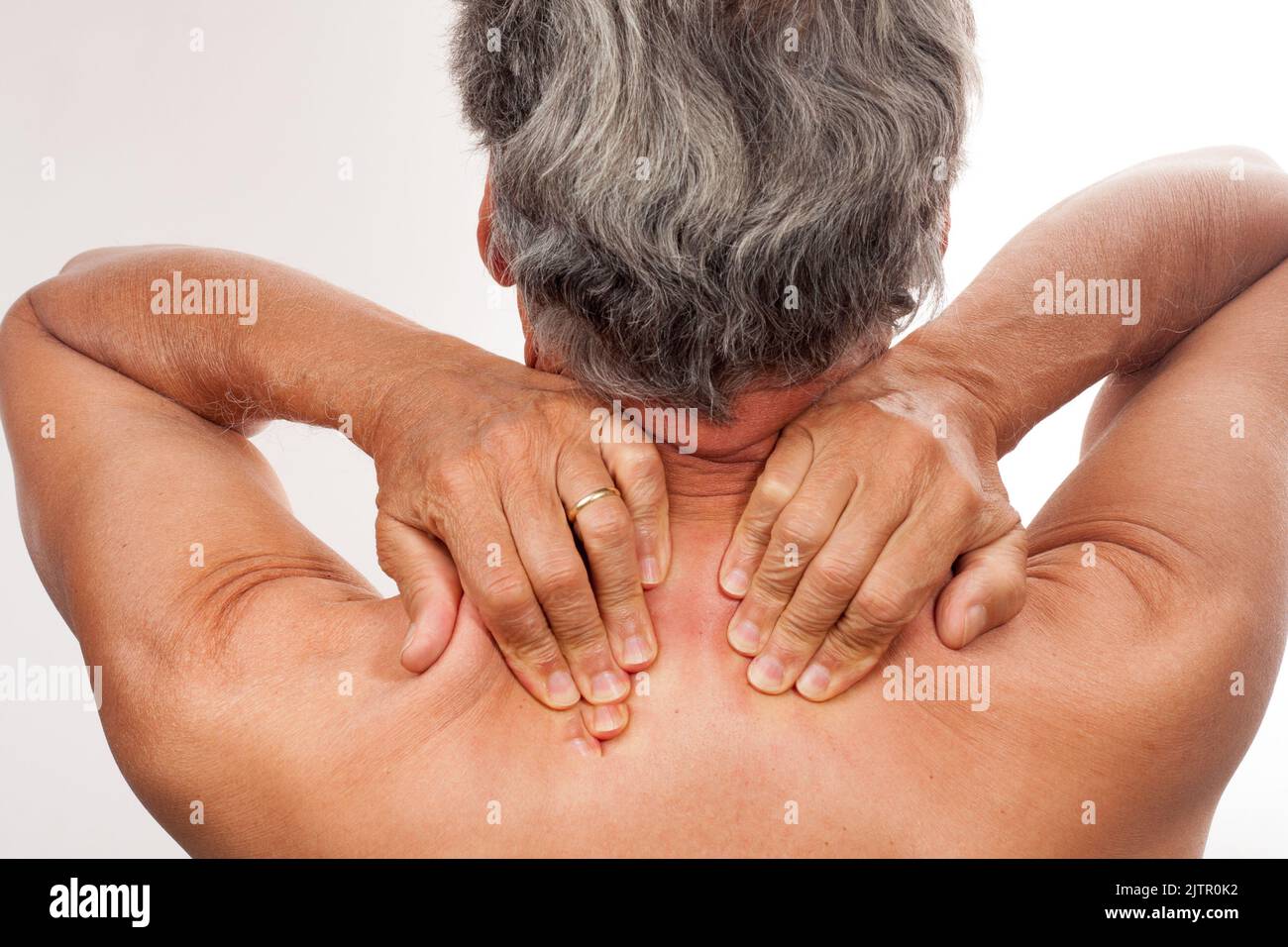 Uomo maturo 60plus massaggiando i muscoli del trapezio per alleviare il dolore Foto Stock