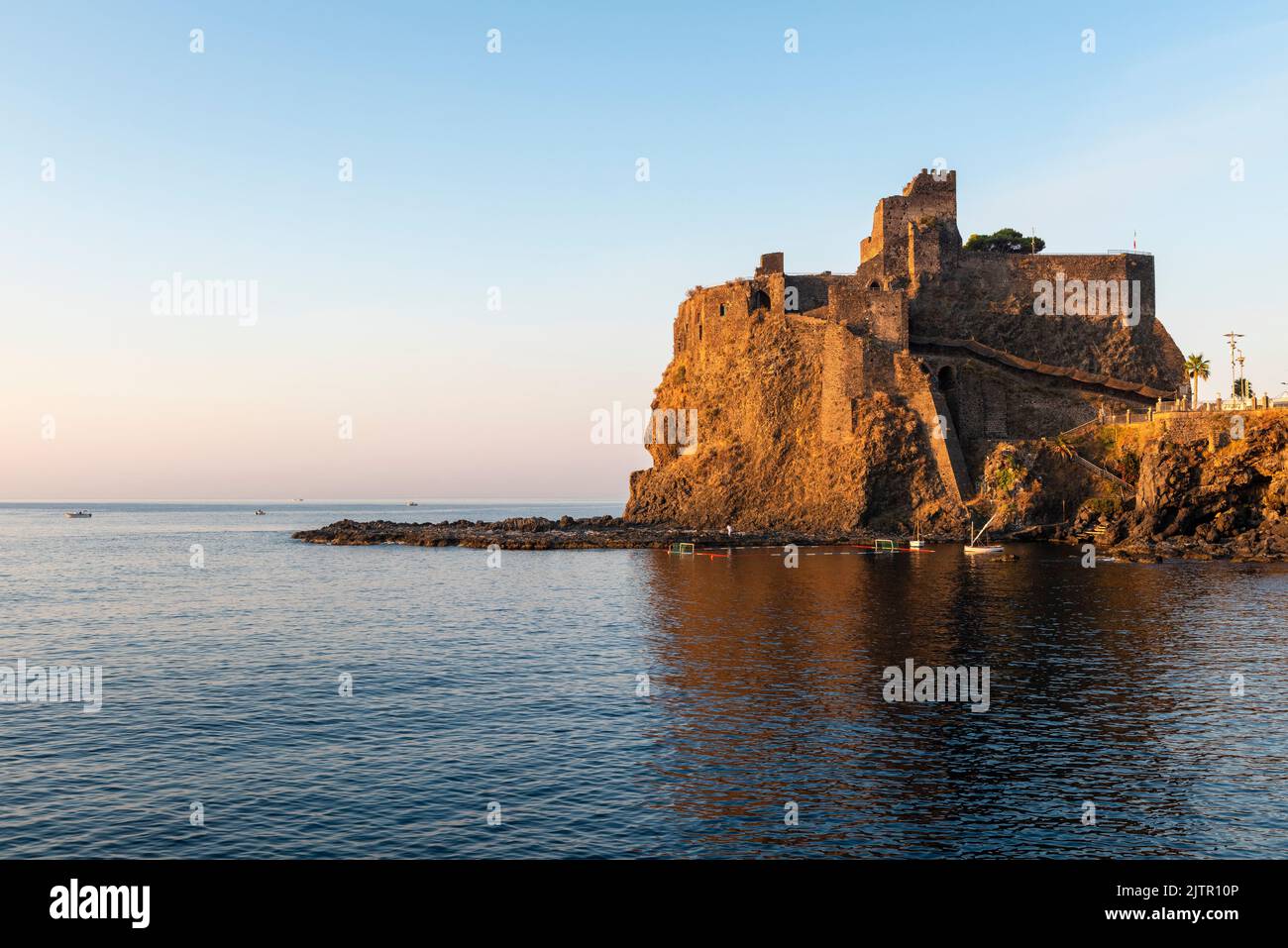 Il castello normanno (1076) ad Aci Castello, Sicilia, visto all'alba. Sorge su un alto affioramento di basalto (lava) e si basa su una fortezza bizantina del 7c Foto Stock