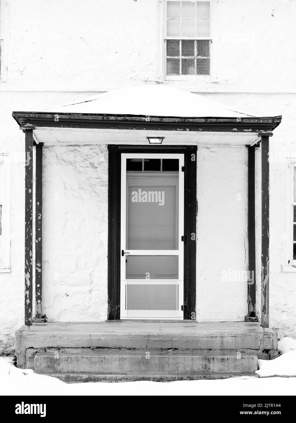 Una scala di grigi verticale ripresa di una porta di una vecchia casa. Foto Stock
