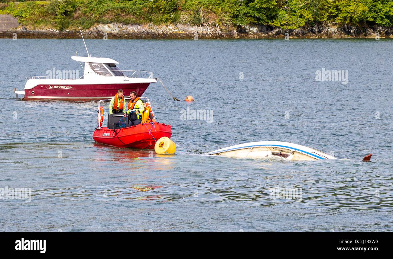 Local Harbour Master rimuove lo yacht affondato trainandolo lontano dall'ormeggio con Waly Boat Foto Stock