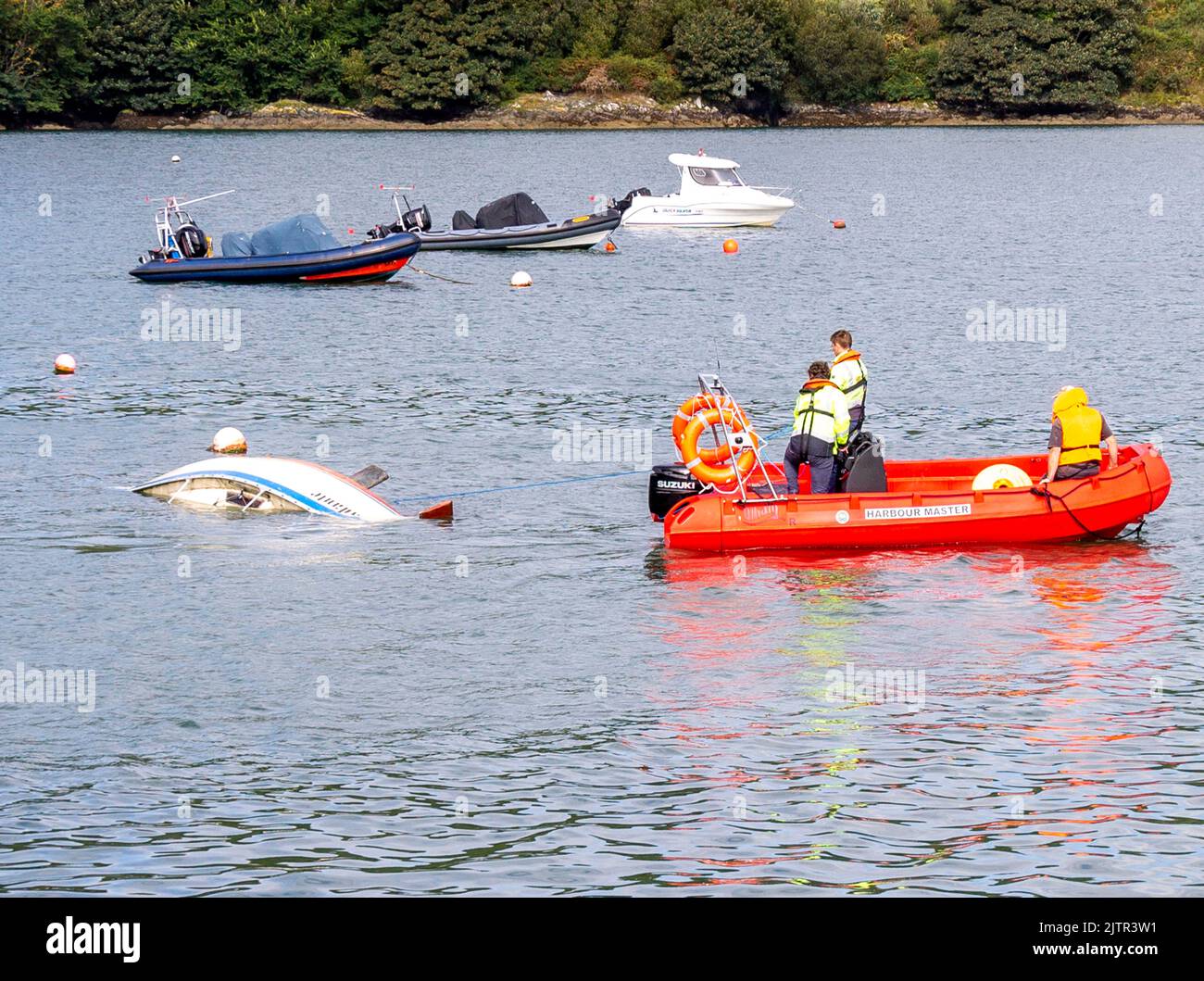 Local Harbour Master rimuove lo yacht affondato trainandolo lontano dall'ormeggio con Waly Boat Foto Stock