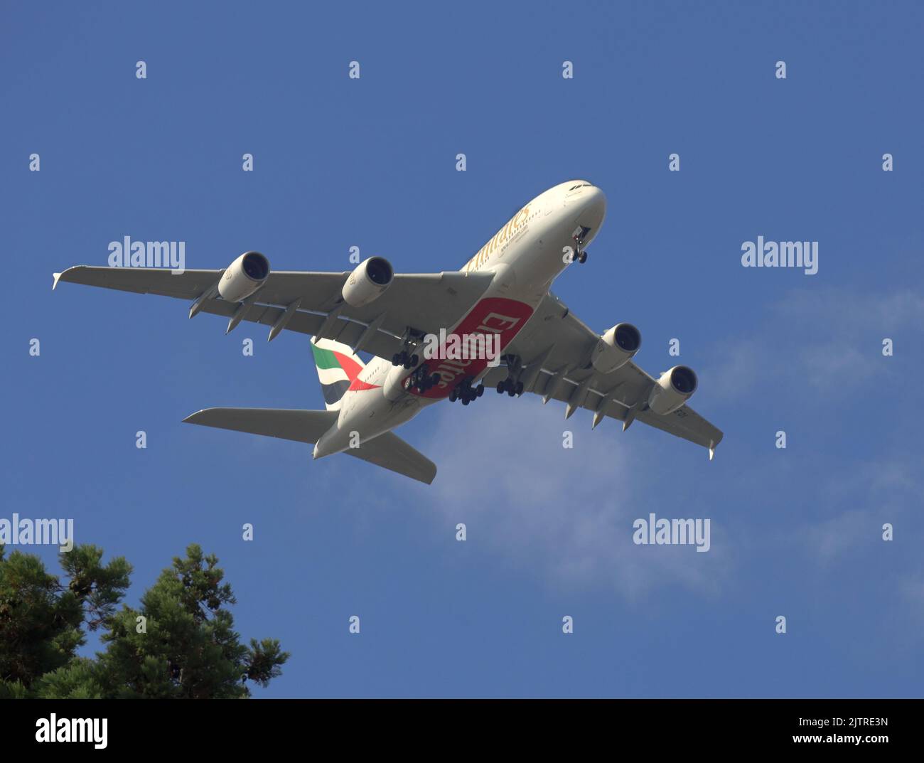 Jet Aeroplano passeggeri che vola direttamente sopra in un cielo blu brillante Foto Stock