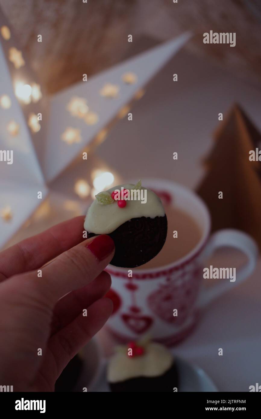 Biscotti Chcoccolate immersi in cioccolato bianco e ricoperti di caramelle/dolci per creare mini budini natalizi. Foto Stock