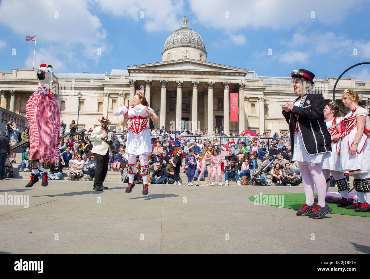 La gente guarda i ballerini Morris mentre si riuniscono per le celebrazioni del giorno di San Giorgio a Trafalgar Square, nel centro di Londra. Foto Stock