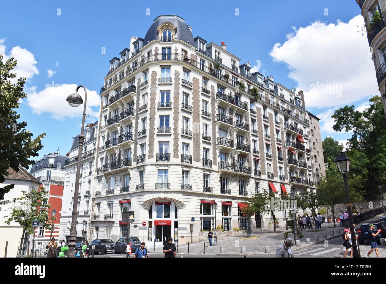 Imponente edificio di appartamenti su 7 piani più un mansarda mansardato di fronte pl.Marcel Aymé, a Parigi, di pietra color crema con riempimento in mattoni Foto Stock