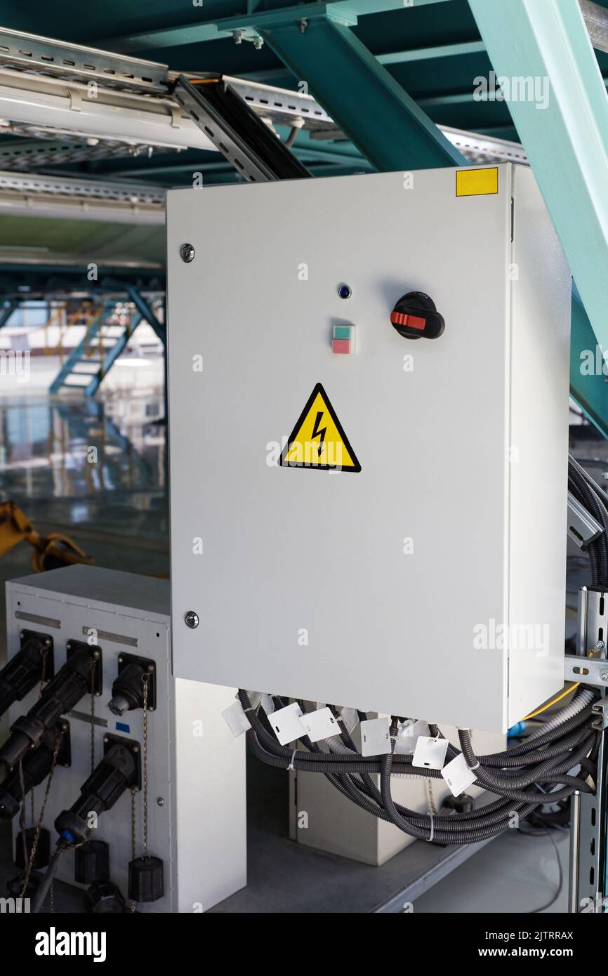 Scatola di alimentazione incernierata grigia in officina industriale Foto Stock