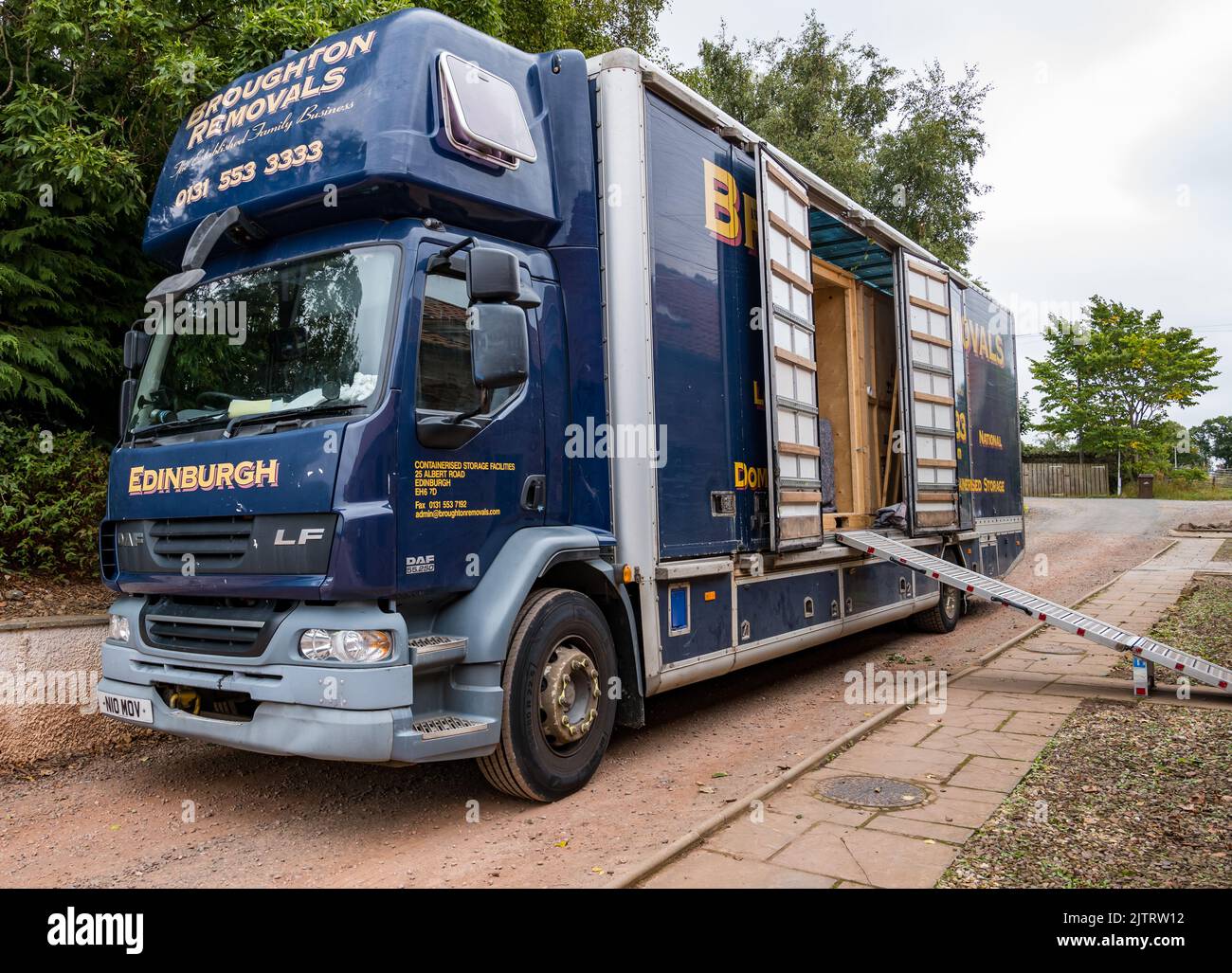 Imballaggio e spostamento casa con Broughton rimozioni camion deposito container parcheggiato fuori casa, Scozia, Regno Unito Foto Stock