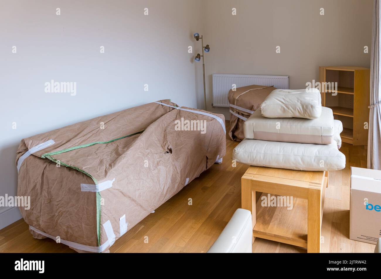Imballaggio e spostamento casa con divano e poltrona mobili avvolti in salotto, Scozia, Regno Unito Foto Stock