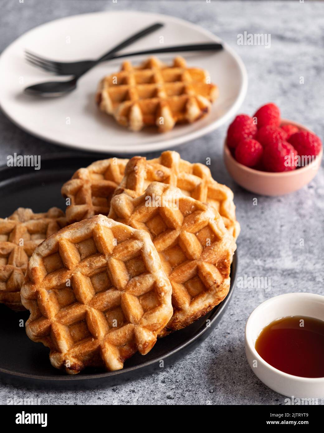 Waffle su un piatto con lamponi Foto Stock