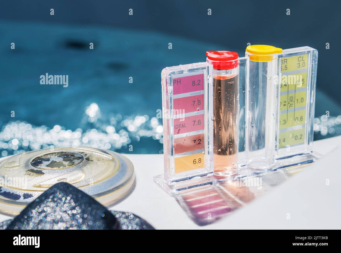 Closeup del Kit di prova manuale di qualità dell'acqua con scala di colore per PH e livello di cloro. Piscina residenziale cura, trattamento e test di routine. Foto Stock