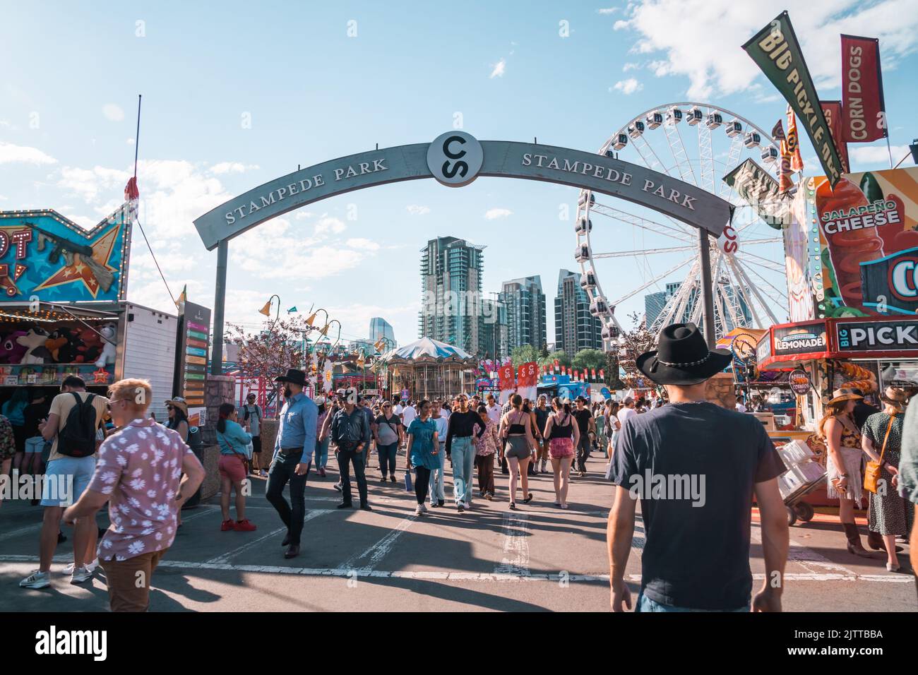 Calgary, Alberta, Canada - 16 luglio 2022: Una folla di persone entra nello Stampede Park, il carnevale a metà strada e l'area giochi Foto Stock