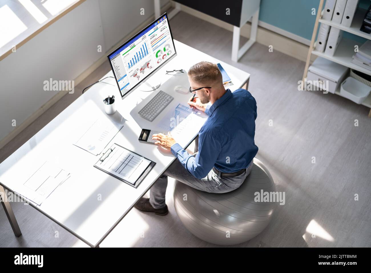 Correggere la postura alla scrivania in ufficio usando la sfera di idoneità Foto Stock