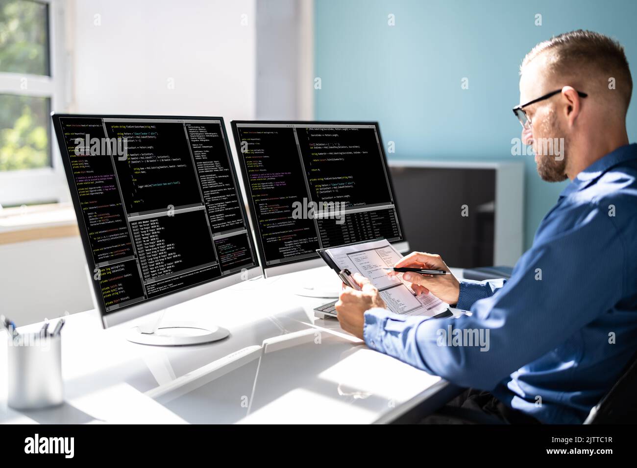 Programmatore di computer che scrive il codice di programma sul computer in Office Foto Stock