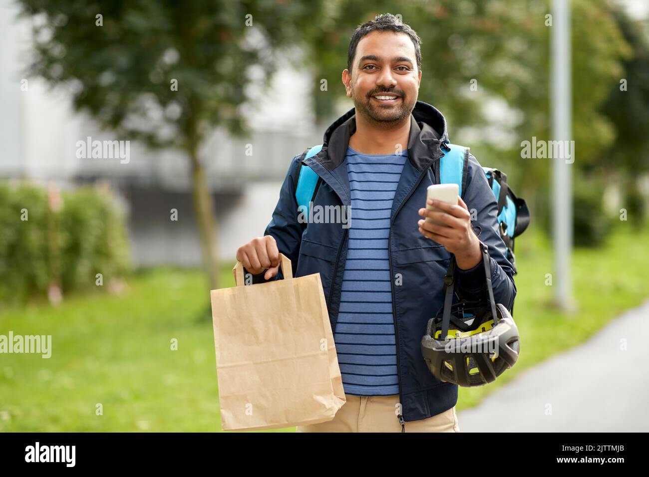 consegna uomo con cibo da asporto in borsa e telefono Foto Stock