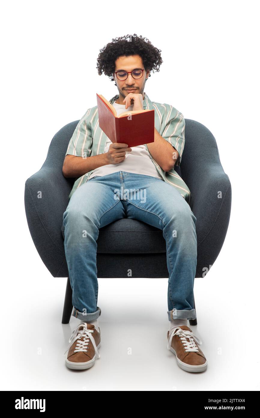 pensare uomo in occhiali leggere libro in sedia Foto Stock